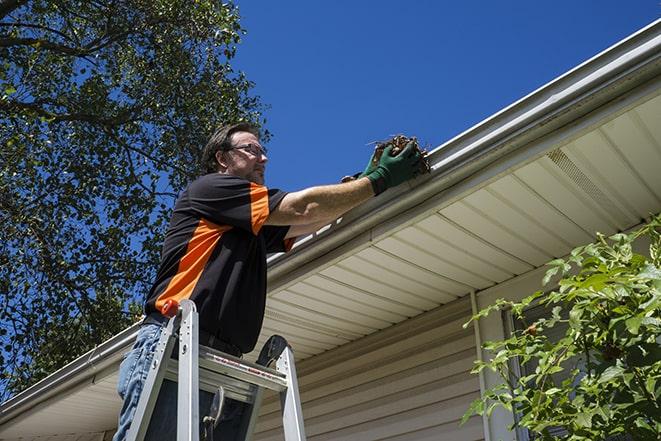 a repairman working on a broken gutter system in Aventura